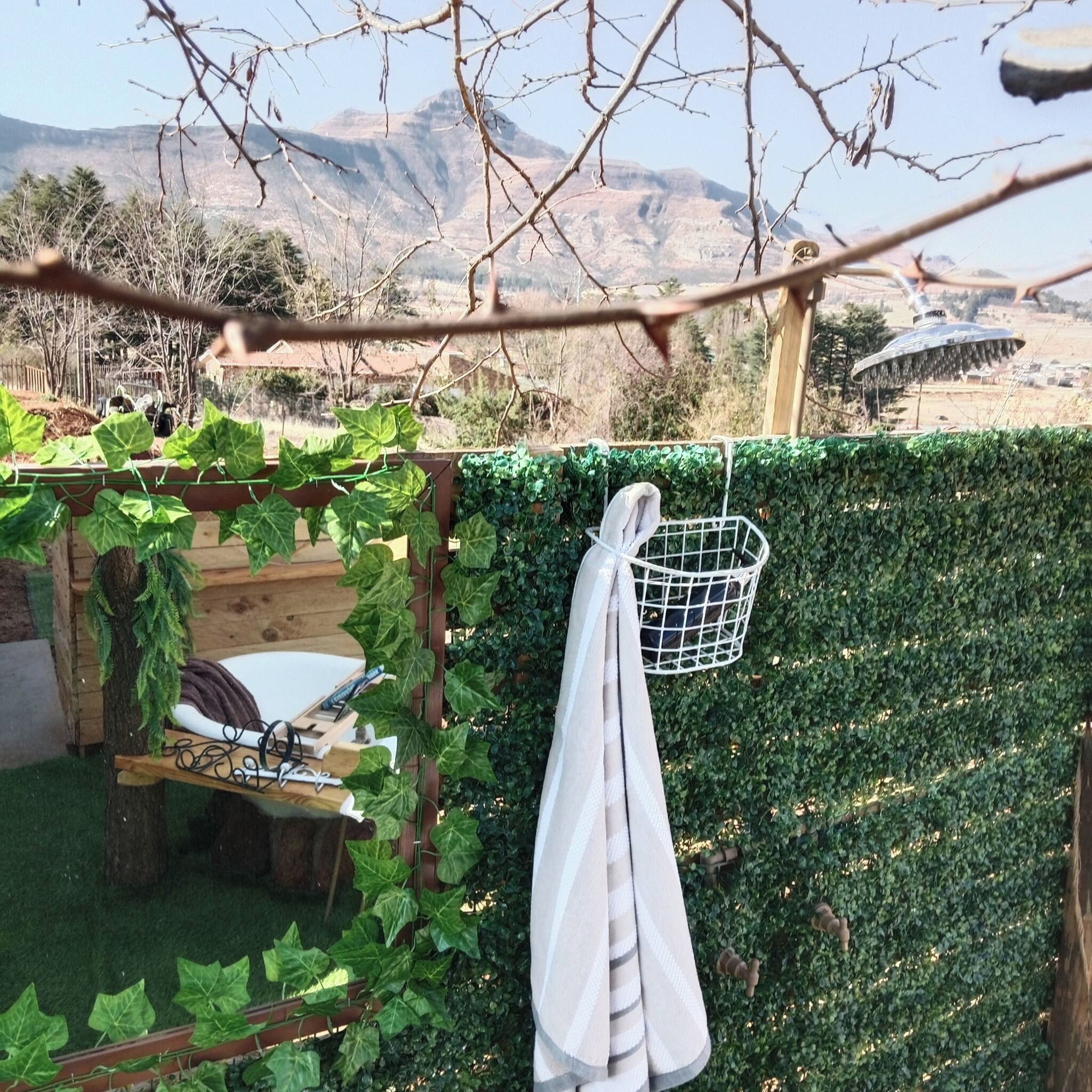 Um jardim com pérgola de madeira, plantas trepadeiras, uma cadeira branca e uma cesta de metal.