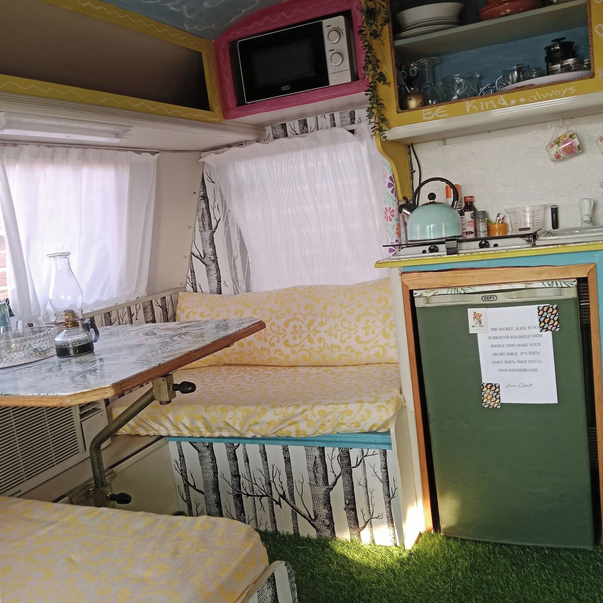 Un espace de vie compact comprenant un coin cuisine, un coin repas et un petit coin salon.