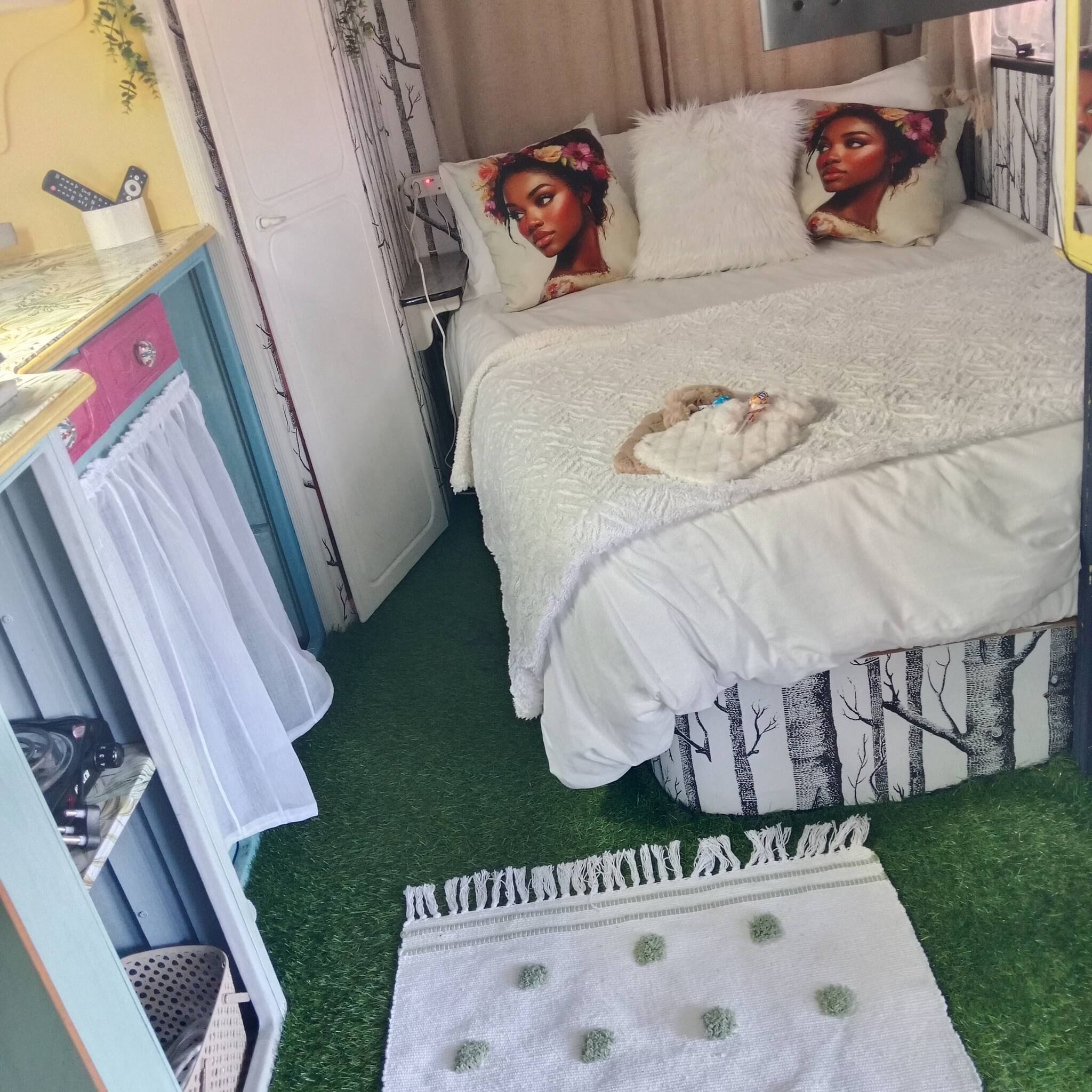 A bedroom with a bed, a bedside table, a wardrobe, and a small rug.