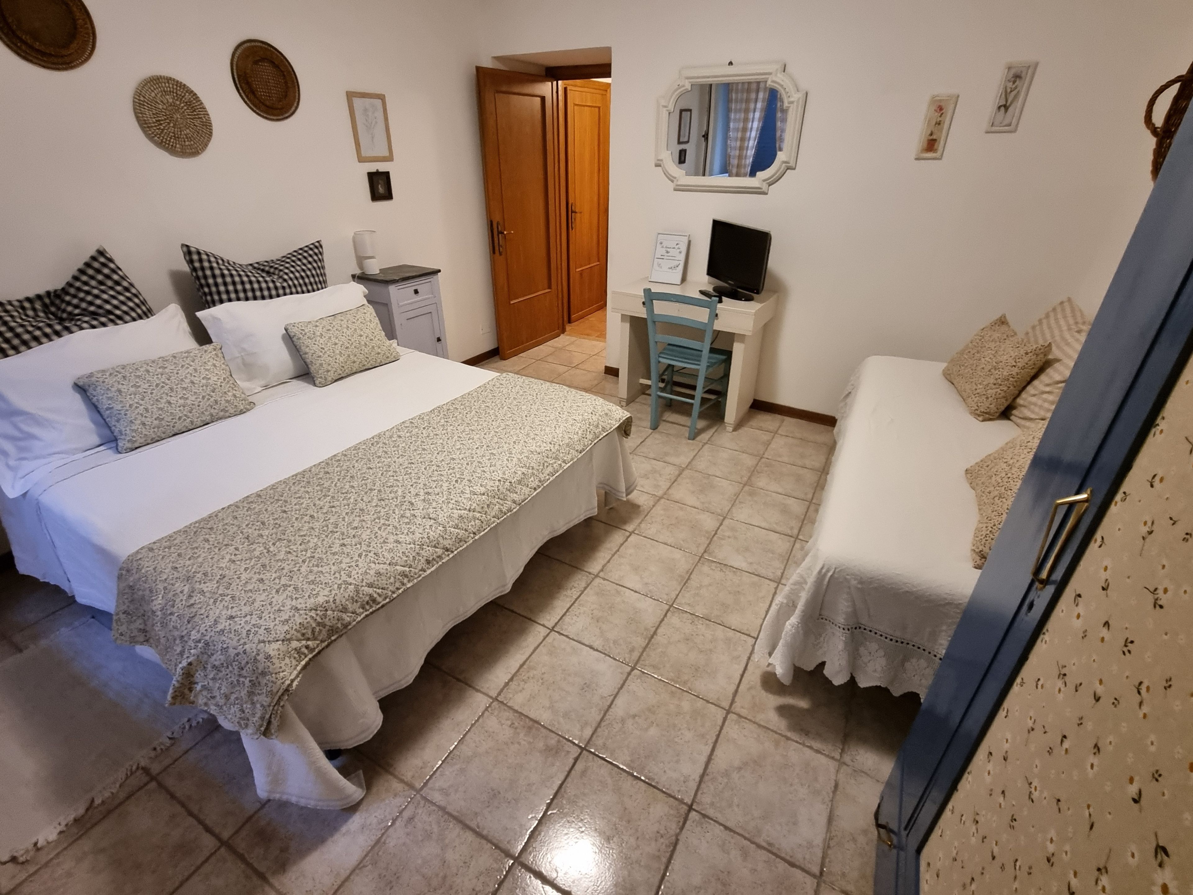 Una camera da letto con un letto, una scrivania, una sedia e un armadio.