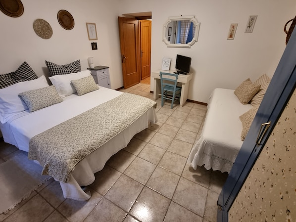 Un dormitorio con cama, escritorio, silla y armario.