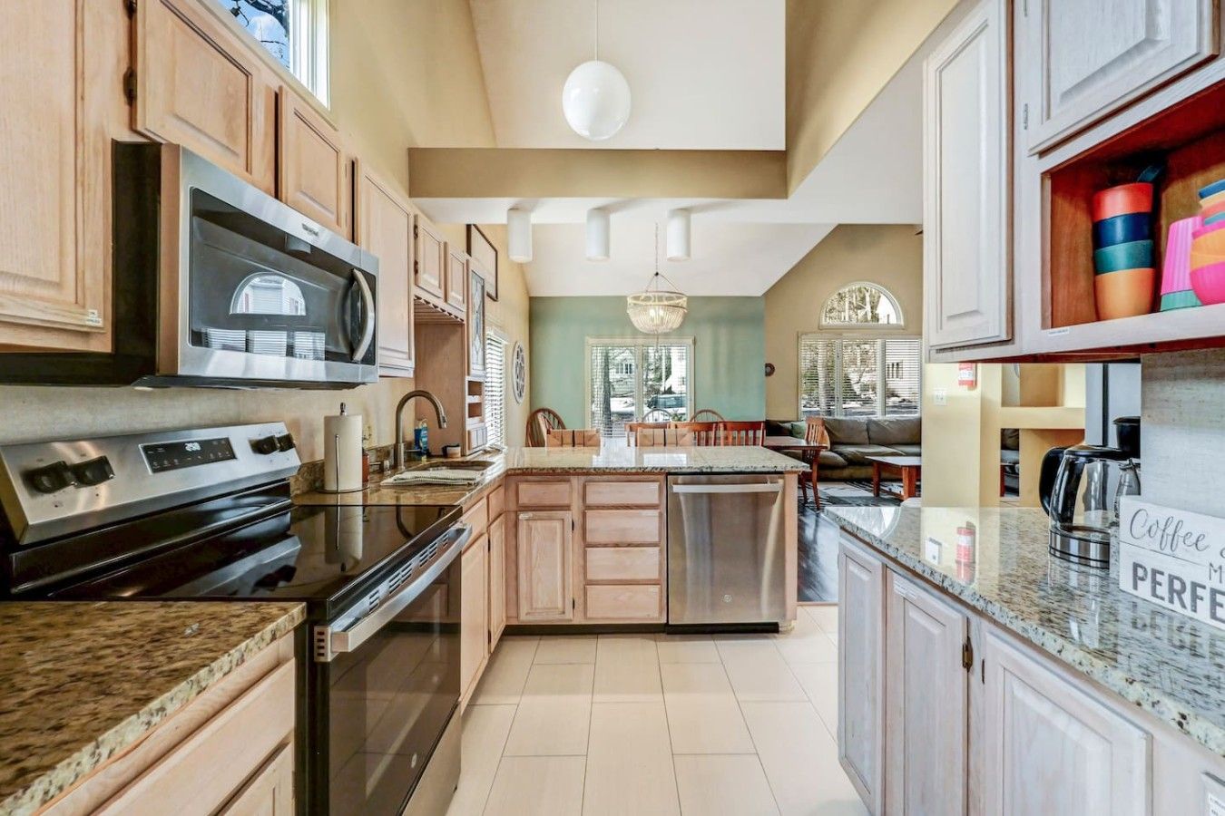 A modern kitchen with stainless steel appliances, wooden cabinets, and a central island.