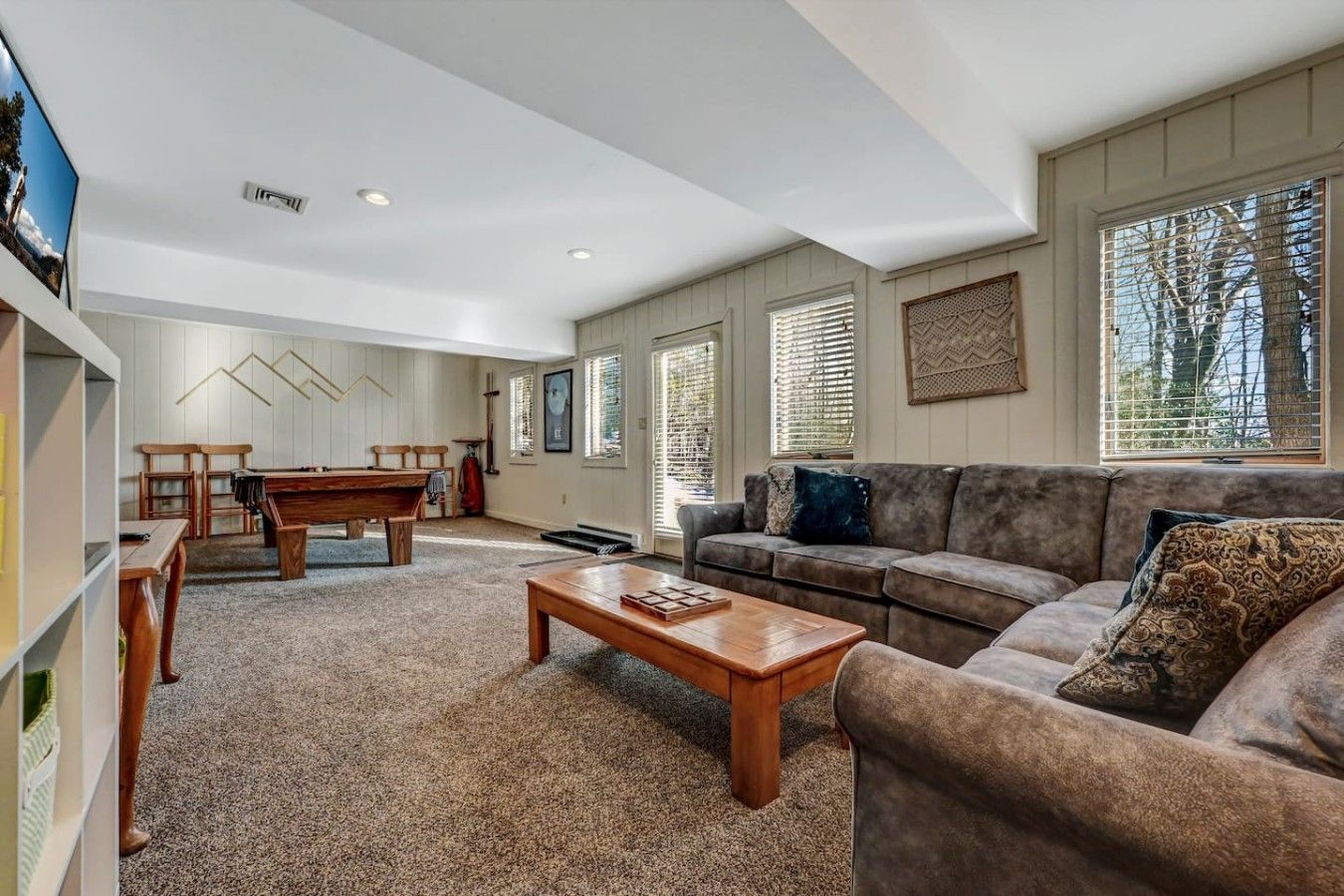 A spacious living room with a pool table, a sofa, and a coffee table.