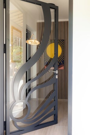 Una porta moderna amb un disseny únic, un panell de vidre i un pom d'acer.