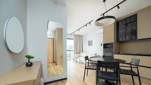 Eine moderne Küche mit Essbereich, einem runden Tisch mit Stühlen und einem großen Spiegel an der Wand.