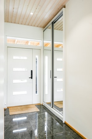 A hallway with a polished floor, a wooden ceiling, and a sliding glass door. - Santa`s Gateway Home, Sauna By Lapland Host (Rovaniemi)