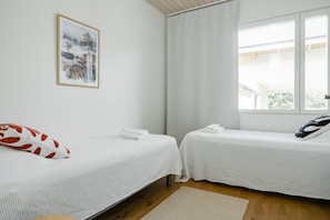 A room with two single beds, a window with blinds, a framed picture on the wall, and a wooden floor. - Santa`s Gateway Home, Sauna By Lapland Host (Rovaniemi)