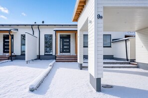 A modern building with a covered entrance and a number '9B' on the wall.