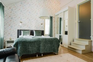 A bedroom with a bed, a nightstand, a dresser, and a mirror.