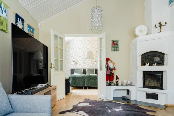 A living room with a television, a fireplace, and a Christmas decoration.