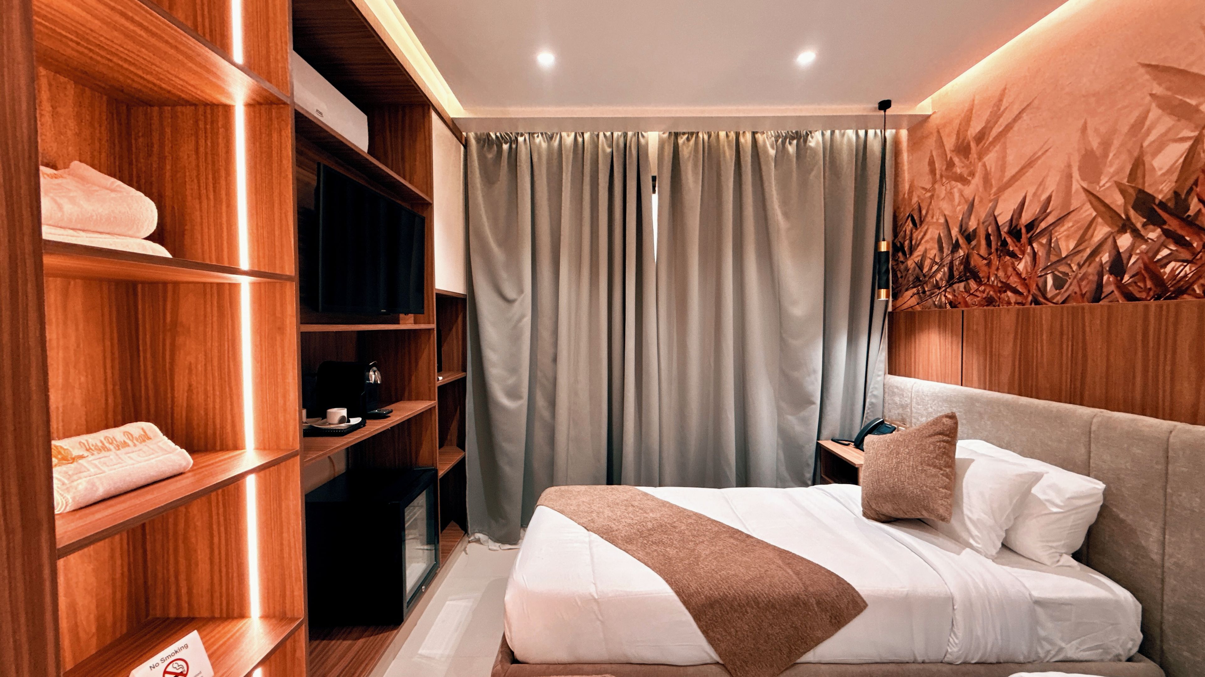 Une chambre d’hôtel comprenant un lit, une armoire, un bureau et une œuvre d’art accrochée au mur.