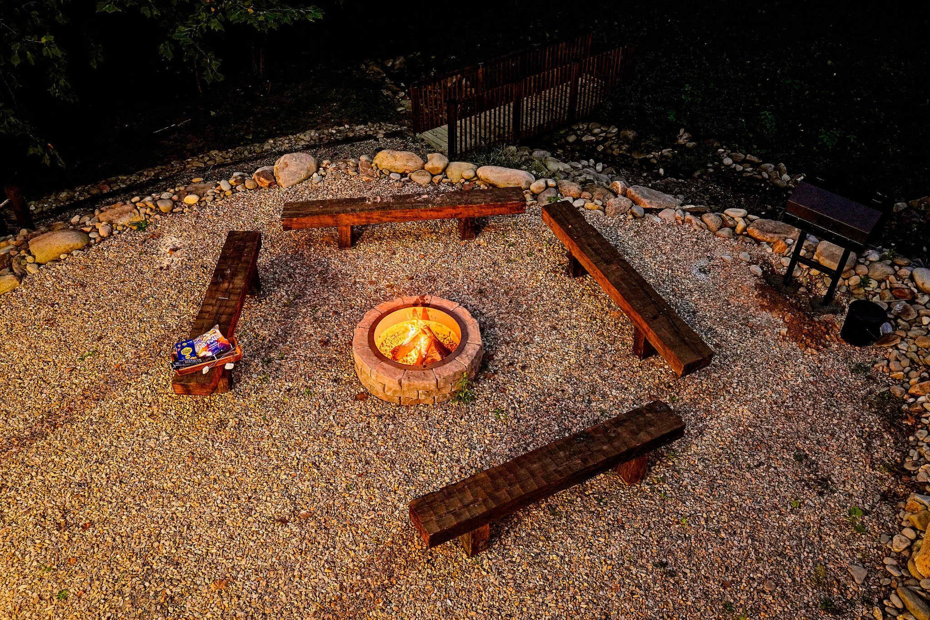A circular seating arrangement around a central fire pit with a gravel ground cover.