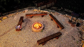 A circular seating arrangement around a central fire pit with a gravel ground cover.