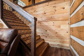 Eine Holztreppe mit Metallgeländer und einem Ledersessel.