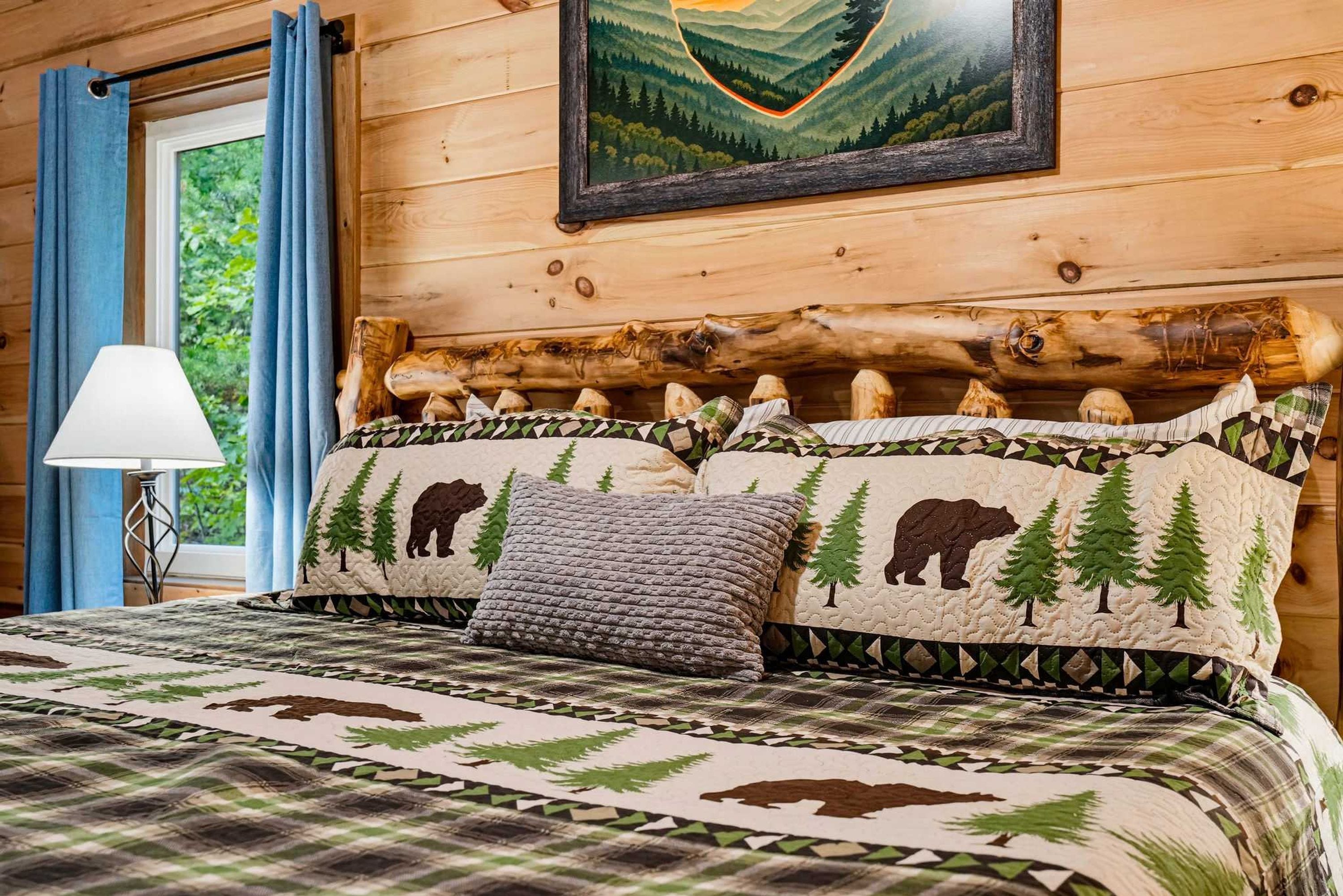 Un dormitorio tipo cabaña de madera con una cama, almohadas y un cuadro en la pared.
