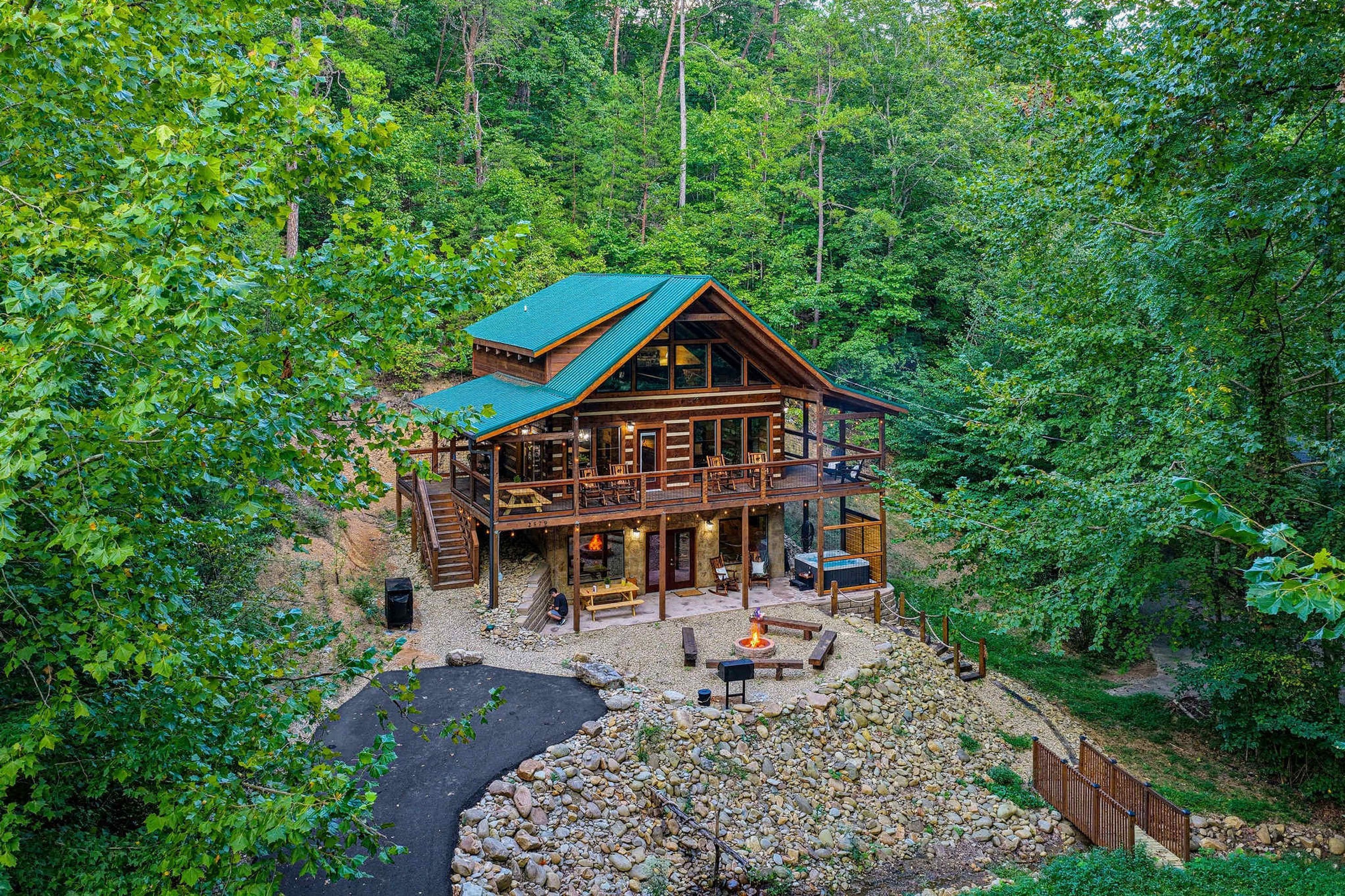 Eine Holzhütte mit einem grünen Dach, umgeben von dichtem Wald.