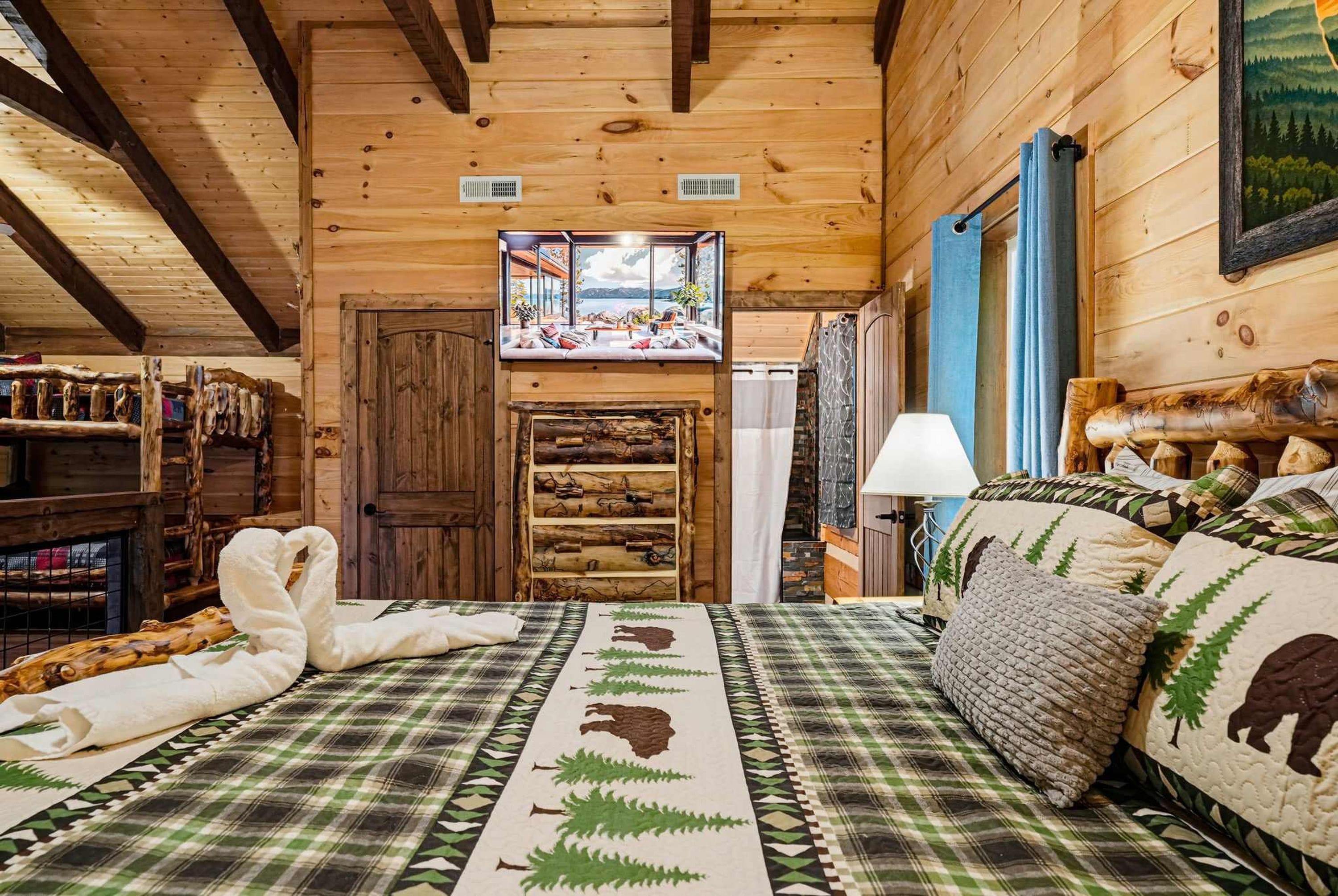 A cozy cabin interior with a bed, a wooden door, and a view through a window.