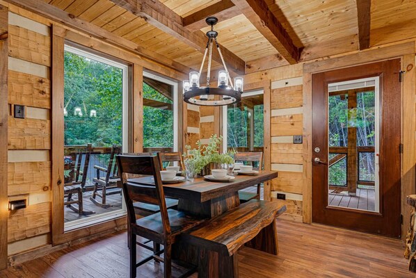 Un interior de madera con una mesa de comedor, sillas y un banco.