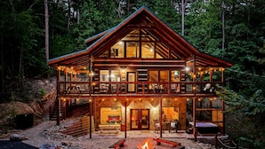 A two-story log cabin with a fire pit and outdoor seating area. - Black Bear Ln in Sevierville (Sevierville)