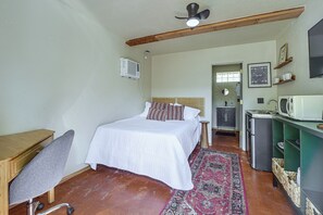A compact bedroom with a bed, bedside table, and a small kitchenette area. - Walk to University & 4th Ave: Tucson Studio (Tucson)