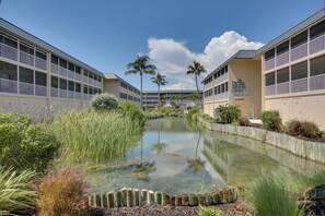Ein Hotel mit einem zentralen Wasserspiel, umgeben von üppiger Vegetation und Palmen.