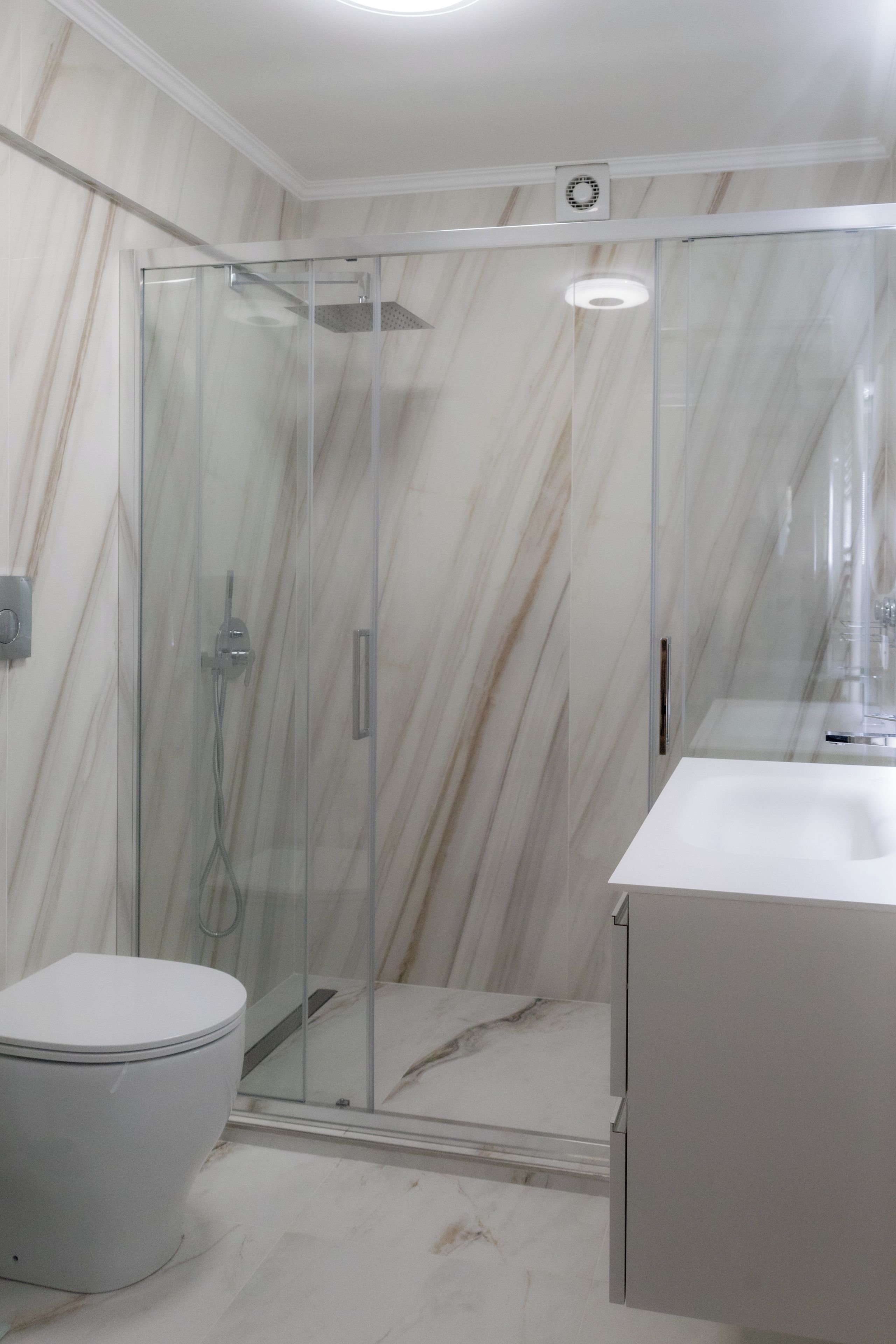 Ein Badezimmer mit Duschkabine, Toilette und Waschbecken.