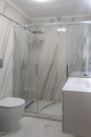 Ein Badezimmer mit Duschkabine, Toilette und Waschbecken.