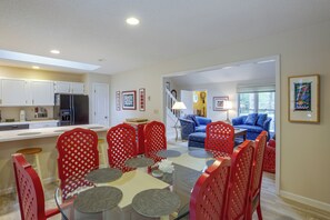 A modern kitchen with white cabinets, a refrigerator, and a dining area with red chairs and round tables. - 2 Mi to Beech Mtn Resort Lifts: Family Home (Banner Elk)