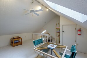 A room with a sloped ceiling, a ceiling fan, a table with chairs, a small wooden table with a basket, and a fire extinguisher on the wall. - 2 Mi to Beech Mtn Resort Lifts: Family Home (Banner Elk)