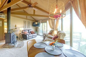 Uma sala de estar espaçosa com lareira, assentos confortáveis e uma grande janela com vista para o exterior.