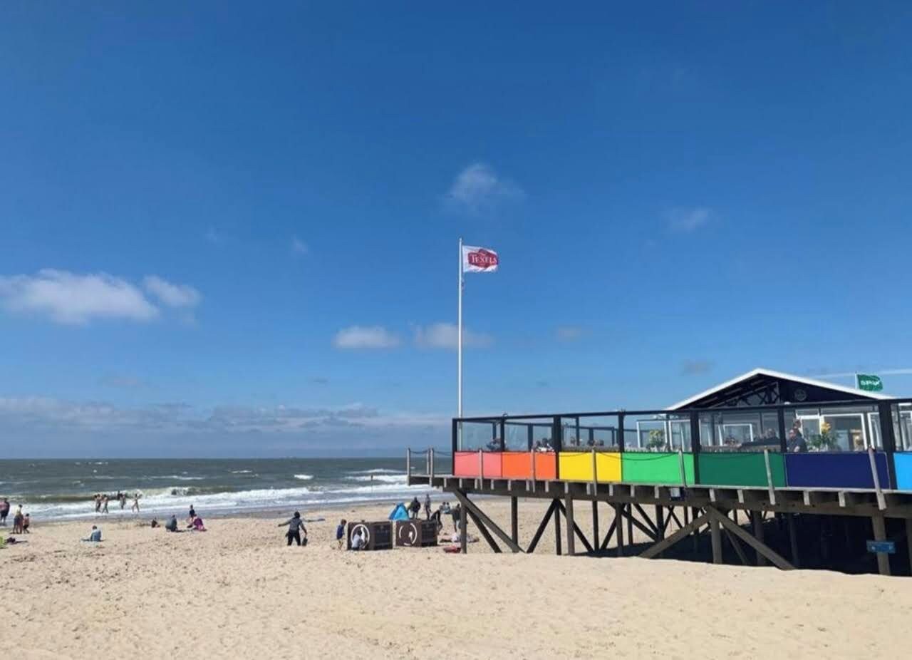 Een strand met een redershut en een vlag.