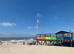 Ein Strand mit einem Rettungsturm und einer Fahne.