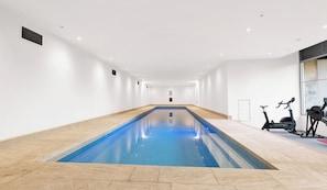 An indoor swimming pool with exercise bikes on one side. - The Chetwynd Elegant West Melbourne Hideaway (West Melbourne)