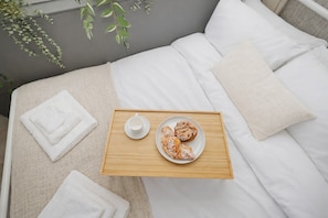 A neatly made bed with white linens, a tray with a cup and pastries, and a plant in the background. - Cosy Tower Bridge | Waterside | St Katharine Docks (Greater London)