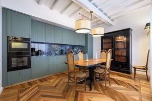 Eine moderne Küche mit Backofen, einer Kaffeemaschine und einer Marmor-Spritzschutzwand.