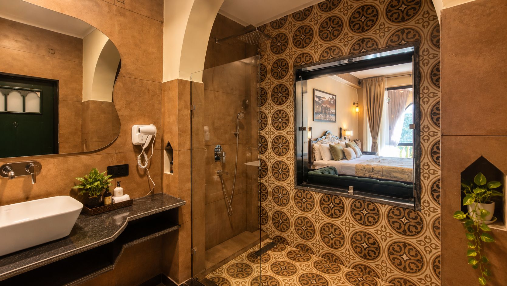 Ein Badezimmer mit einem großen Spiegel, einer Dusche und einem Waschbecken mit Pflanze.