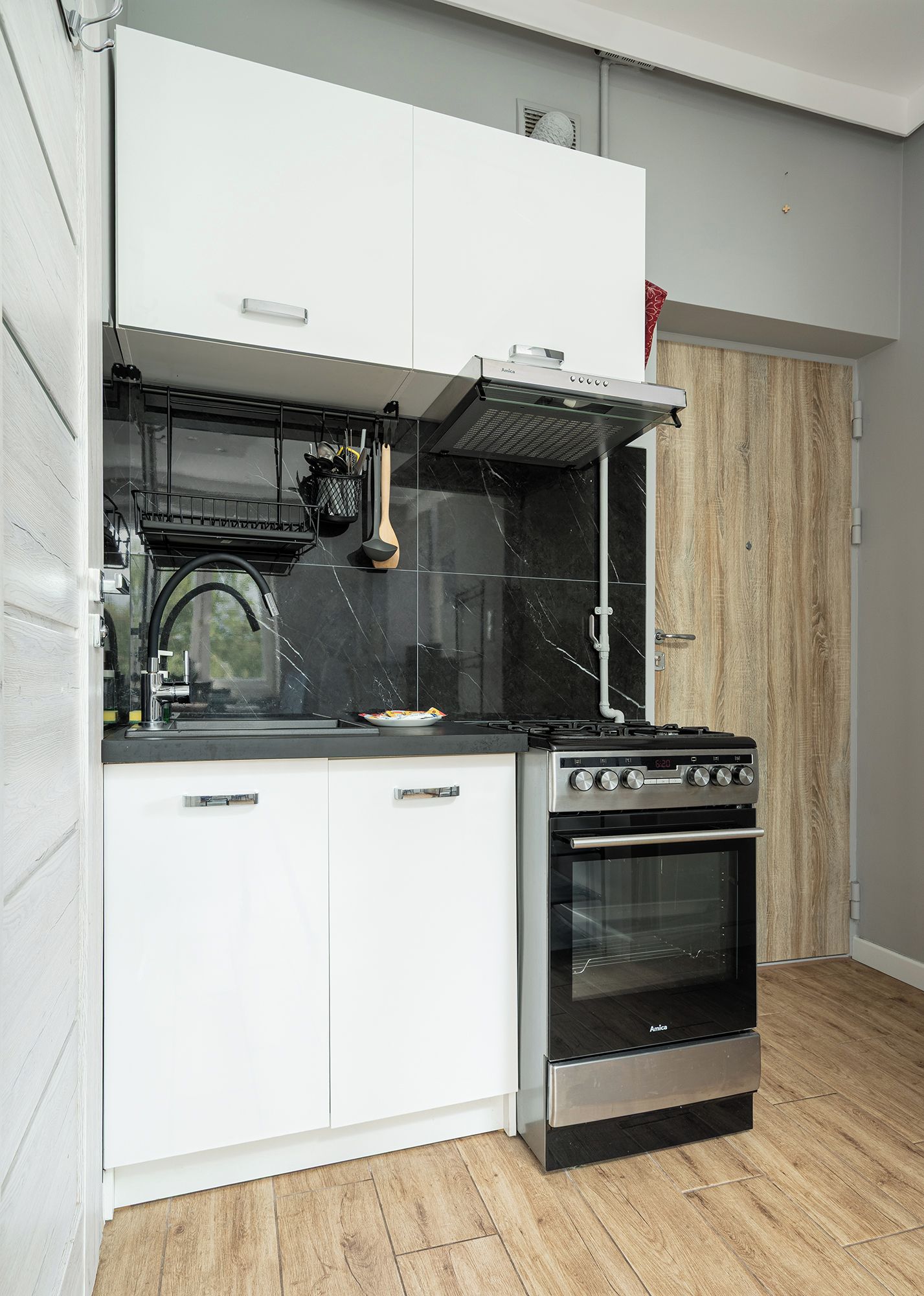 Eine kleine Küche mit eingebautem Backofen, einer Kochplatte und einer Mikrowelle.