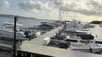 A marina with multiple boats docked at wooden piers.