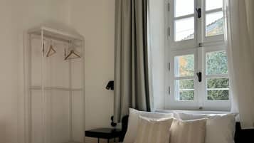 Ein Schlafzimmer mit Bett, Schrank, Fenster und Nachttisch.