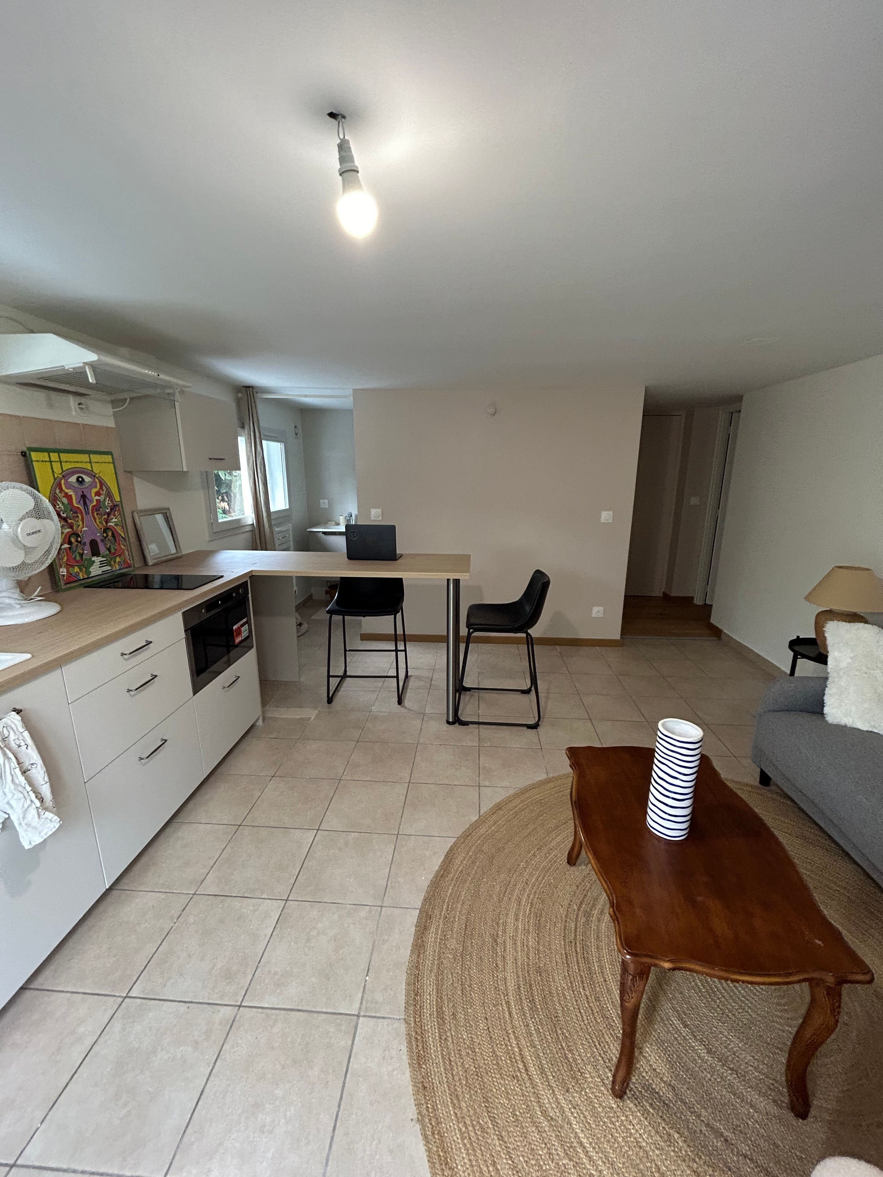 Une cuisine moderne avec un coin repas, un canapé et une table basse.
