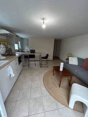 Ein modernes Wohnzimmer mit einer Couch, einem Couchtisch und einem Essbereich mit Tisch und Stühlen.