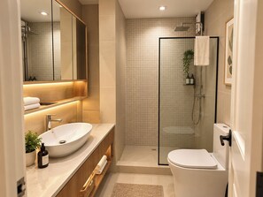A modern bathroom with a large sink, a toilet, a glass-enclosed shower, and a mirror above the sink. - Modern 1BR Executive Suite in Taguig near BGC (Taguig)