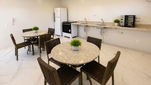 Cozinha moderna com armários brancos, forno embutido e micro-ondas.