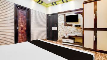 A bedroom with a bed, wardrobe, and a vanity with a mirror.