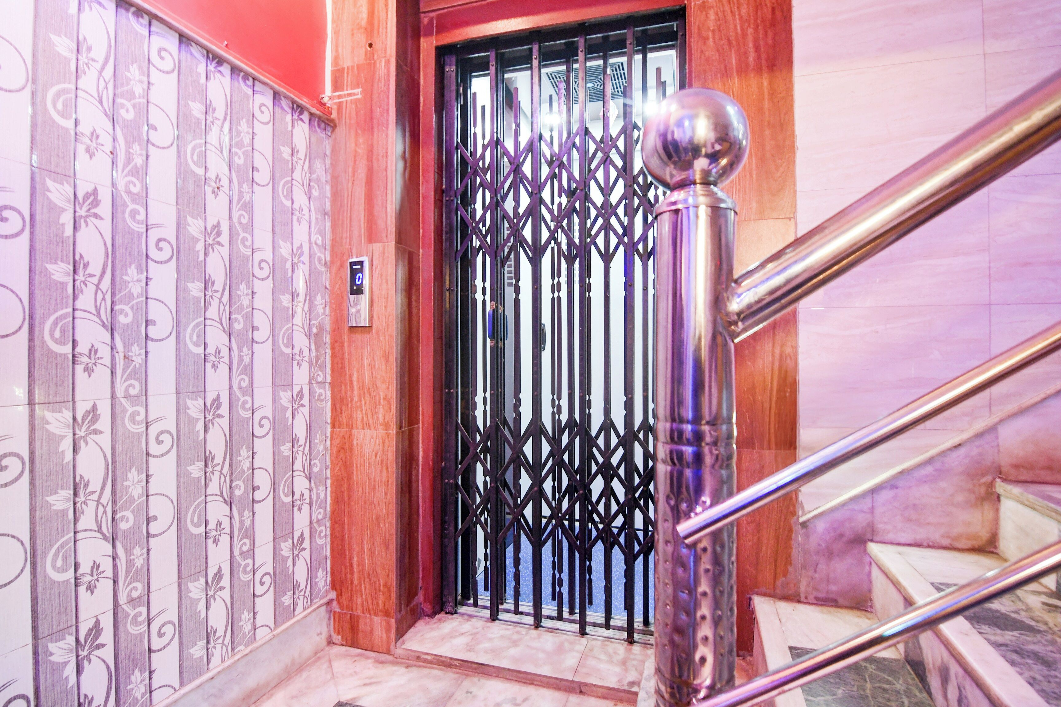Uma escadaria com corrimão de metal e uma porta decorativa com grade metálica.