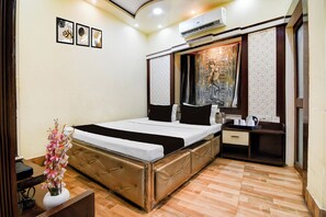 A hotel room with a bed, bedside table, and a mirror. - Hotel O NIT Durgapur Formerly Royal Inn (Durgapur)