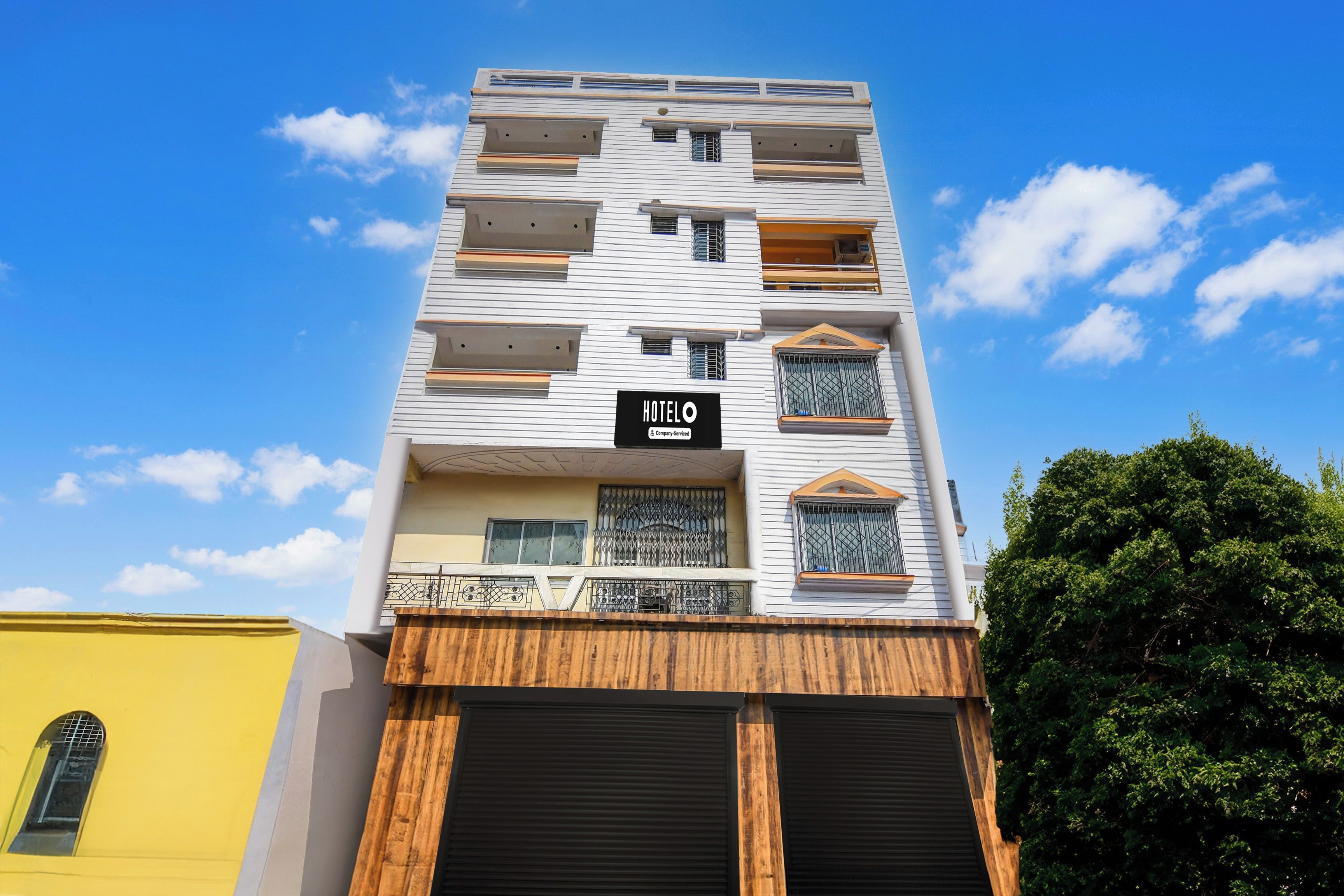 A multi-story hotel building with a sign indicating it is a company-serviced hotel.