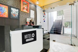 Taulell de recepció d'hotel amb un cartell que indica servei de l'empresa.