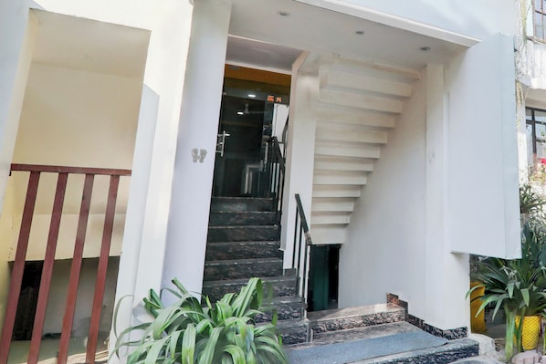 A staircase leading to an interior space with a handrail and a door at the top.