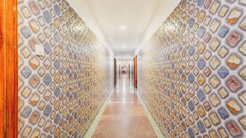 A corridor with patterned walls and a polished floor.